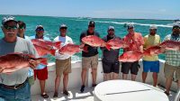 A group of anglers, each holding a Red Snapper they caught on a party boat from Destin, Fl