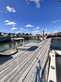 A scenic view of a dock with clear blue skies and calm waters, showcasing the fishing environment.