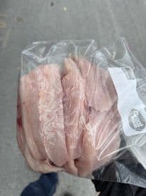 Freshly filleted fish stored in a plastic bag, ready for transport after a fishing trip.