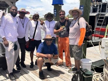 A group of anglers posing together on the dock, showcasing camaraderie after a fishing trip.