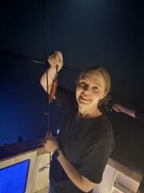 An angler proudly displaying a freshly caught squid while fishing at night, showcasing the excitement of night fishing.
