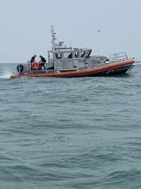 A U.S. Coast Guard vessel is seen navigating through the water, showcasing its robust design and operational readiness.
