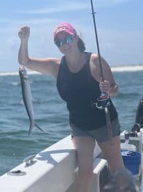 An angler proudly displaying a caught fish while fishing on a sunny day, showcasing the excitement of a successful catch.