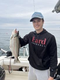 A young angler proudly displaying a large Speckled Trout while fishing off the coast of North Carolina.