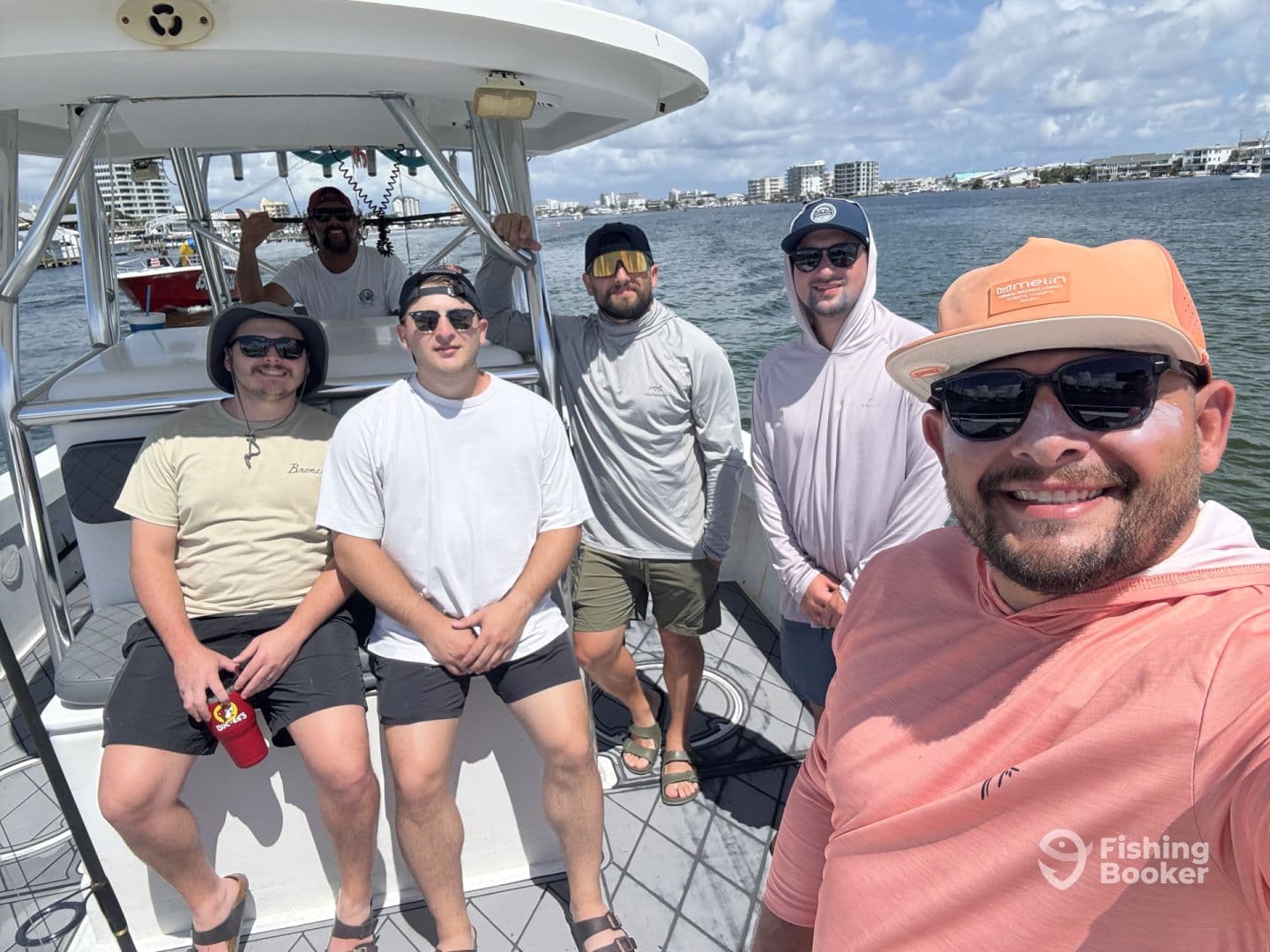 Group of friends enjoying a day on the boat, showcasing a relaxed atmosphere with the scenic waterfront in the background.