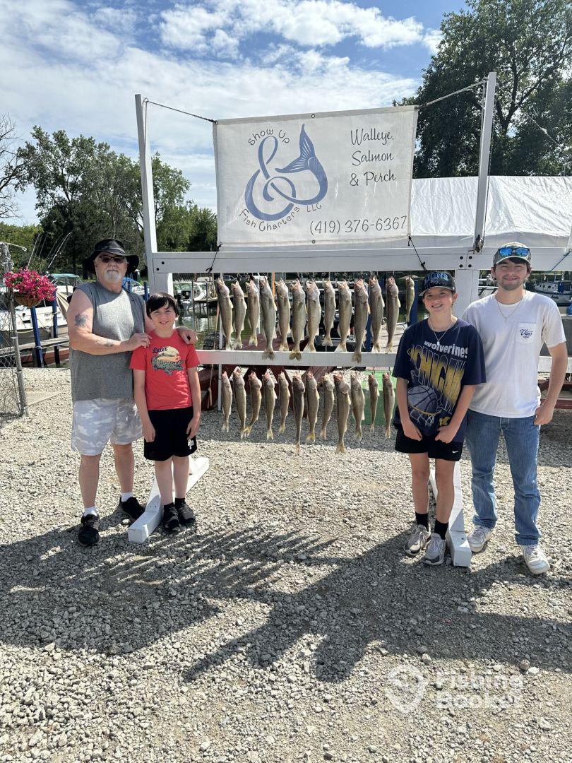 A family poses in front of a catch board displaying an impressive haul of Walleye after a successful fishing trip with Show Up Fish Charters.