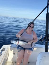 An angler proudly displaying a freshly caught fish while enjoying a day on the water, showcasing the excitement of offshore fishing.