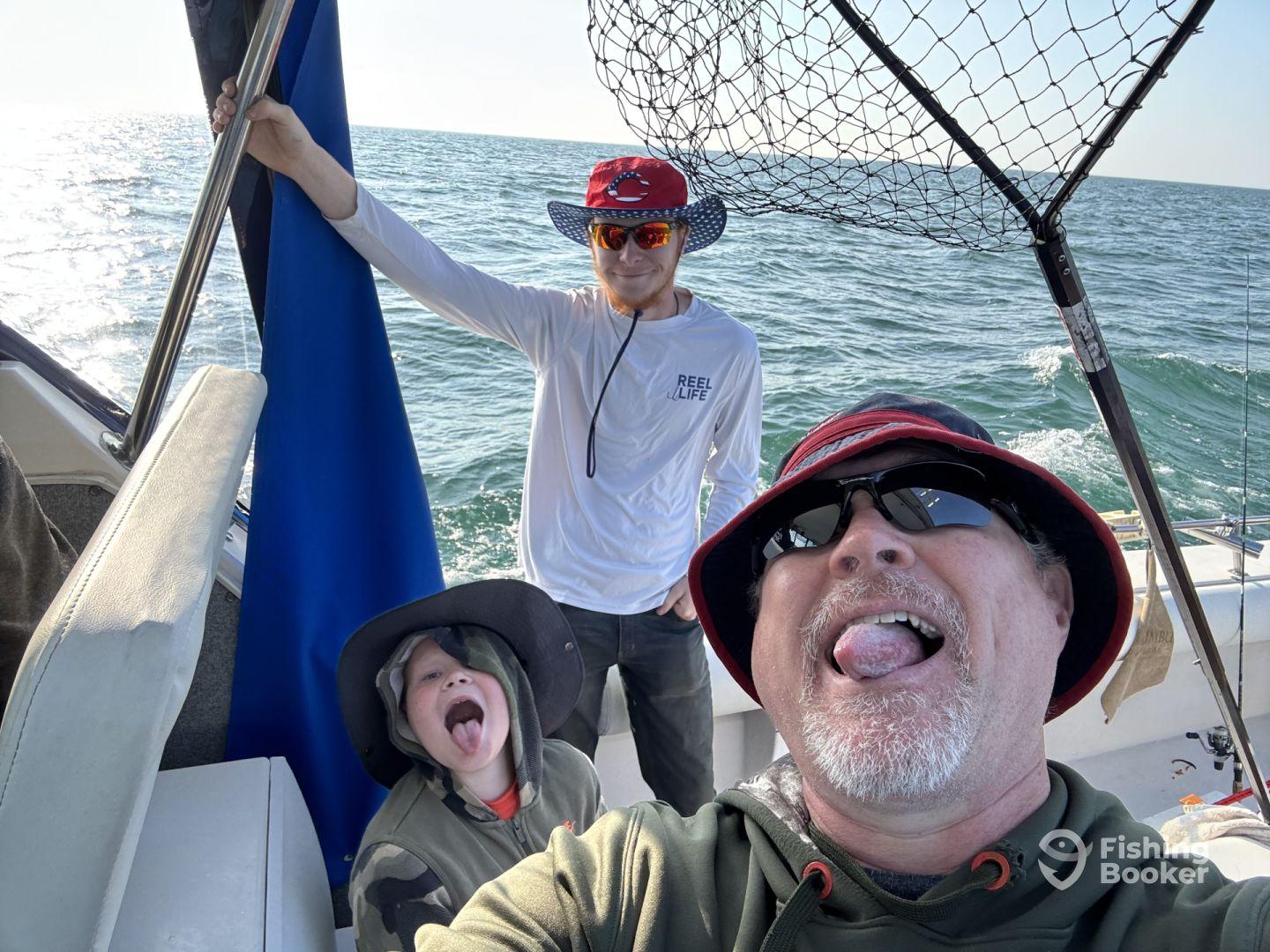 A fun moment captured inside the boat with a father and two kids, enjoying their fishing trip on a sunny day.