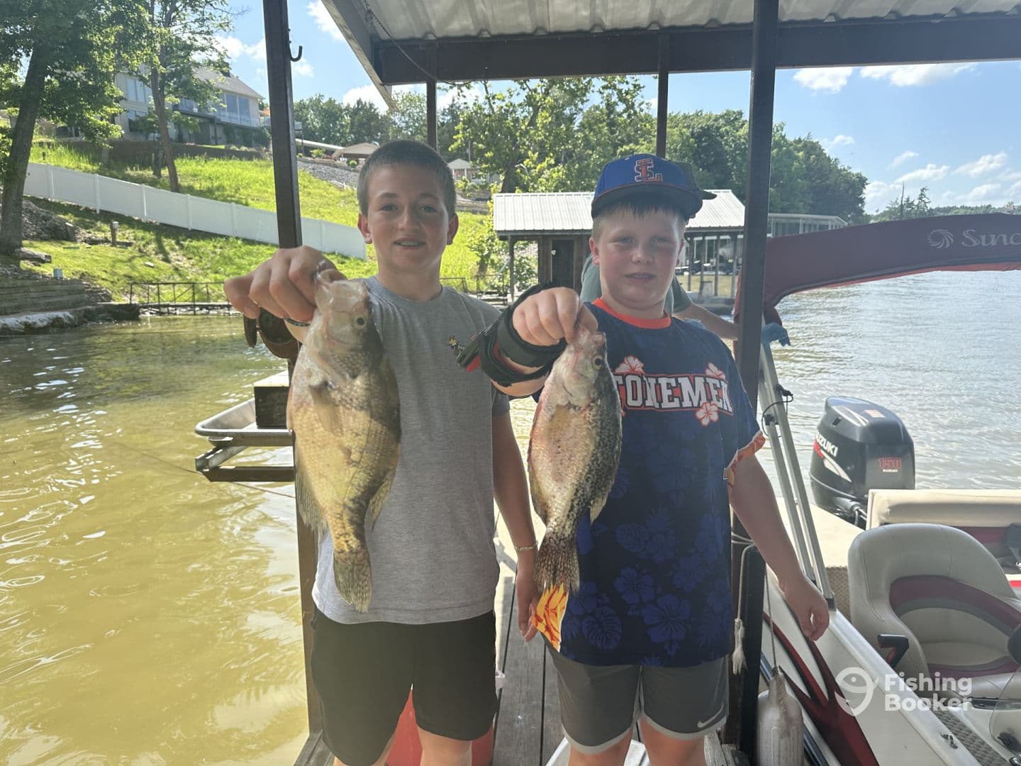 Two young anglers proudly displaying their catches of Crappie while enjoying a sunny day on the lake.