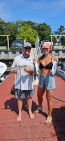 Two anglers proudly displaying their catch of Spanish Mackerel on the dock after a successful fishing trip.