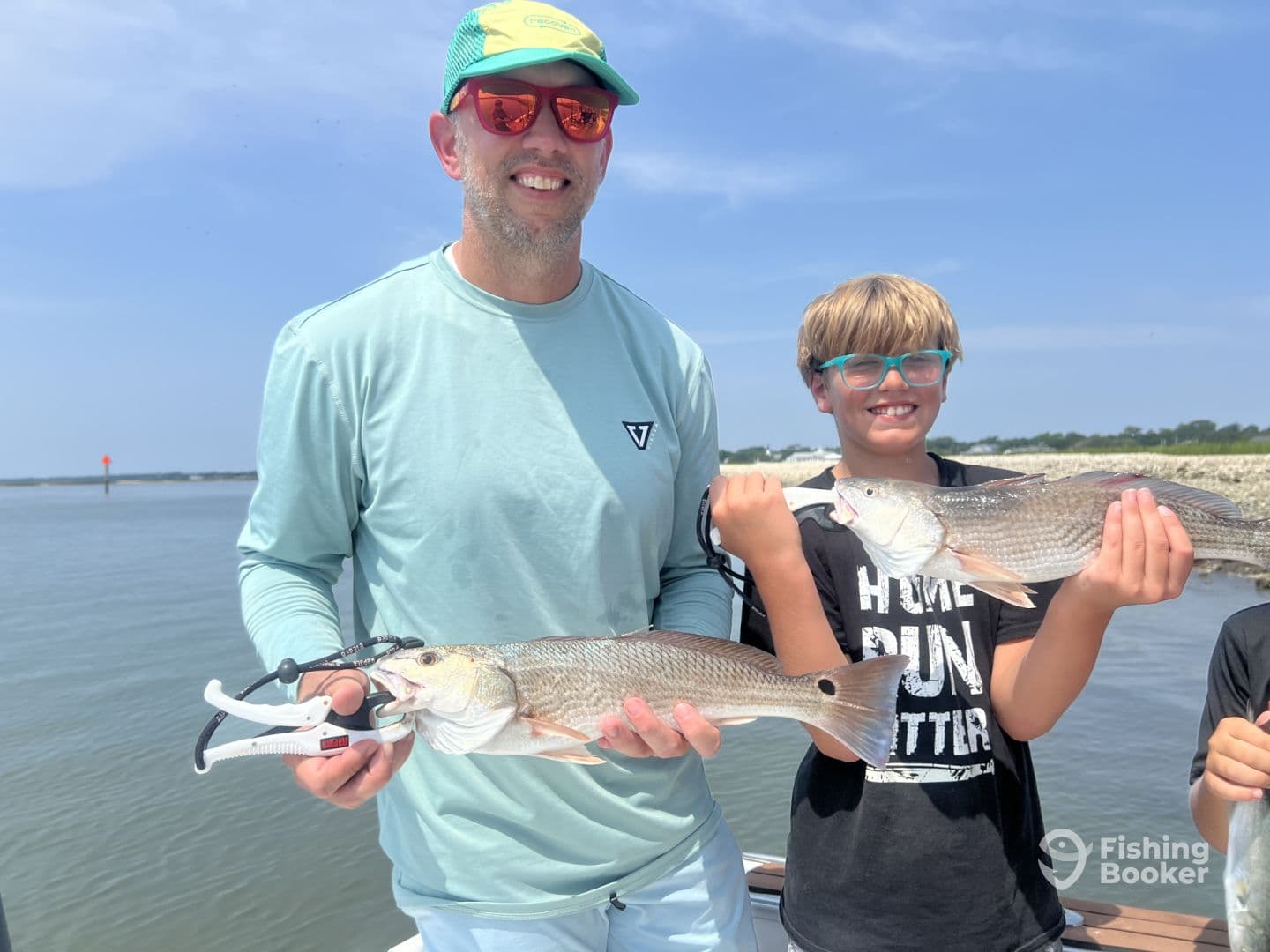 A proud moment for a family fishing trip, showcasing a pair of Redfish caught in a coastal waterway.