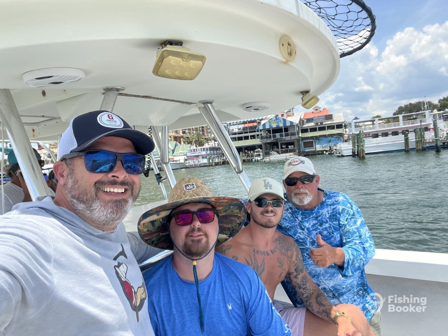 Group of four anglers enjoying a day on a charter boat, with a scenic waterfront backdrop and relaxed atmosphere.
