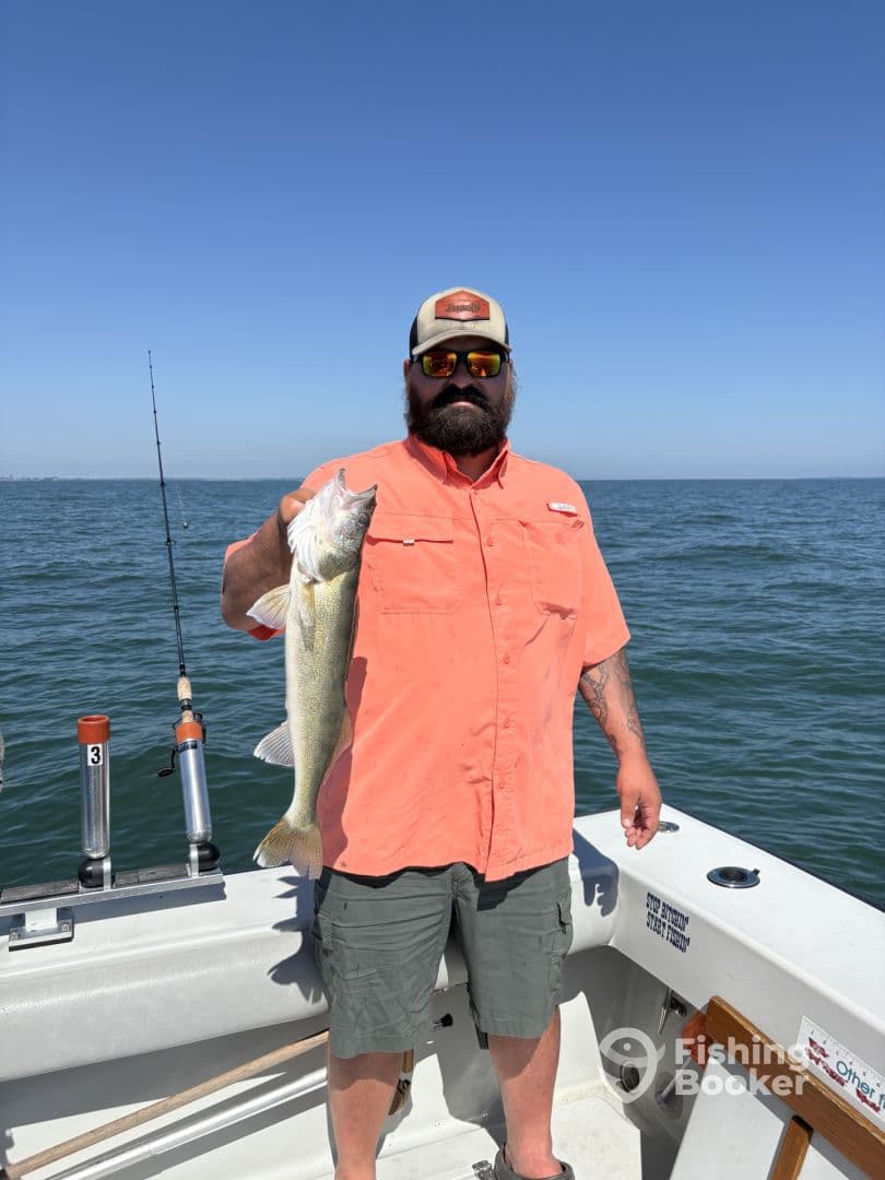 Angler proudly displaying a large Walleye while fishing on a sunny day, showcasing the excitement of a successful catch.
