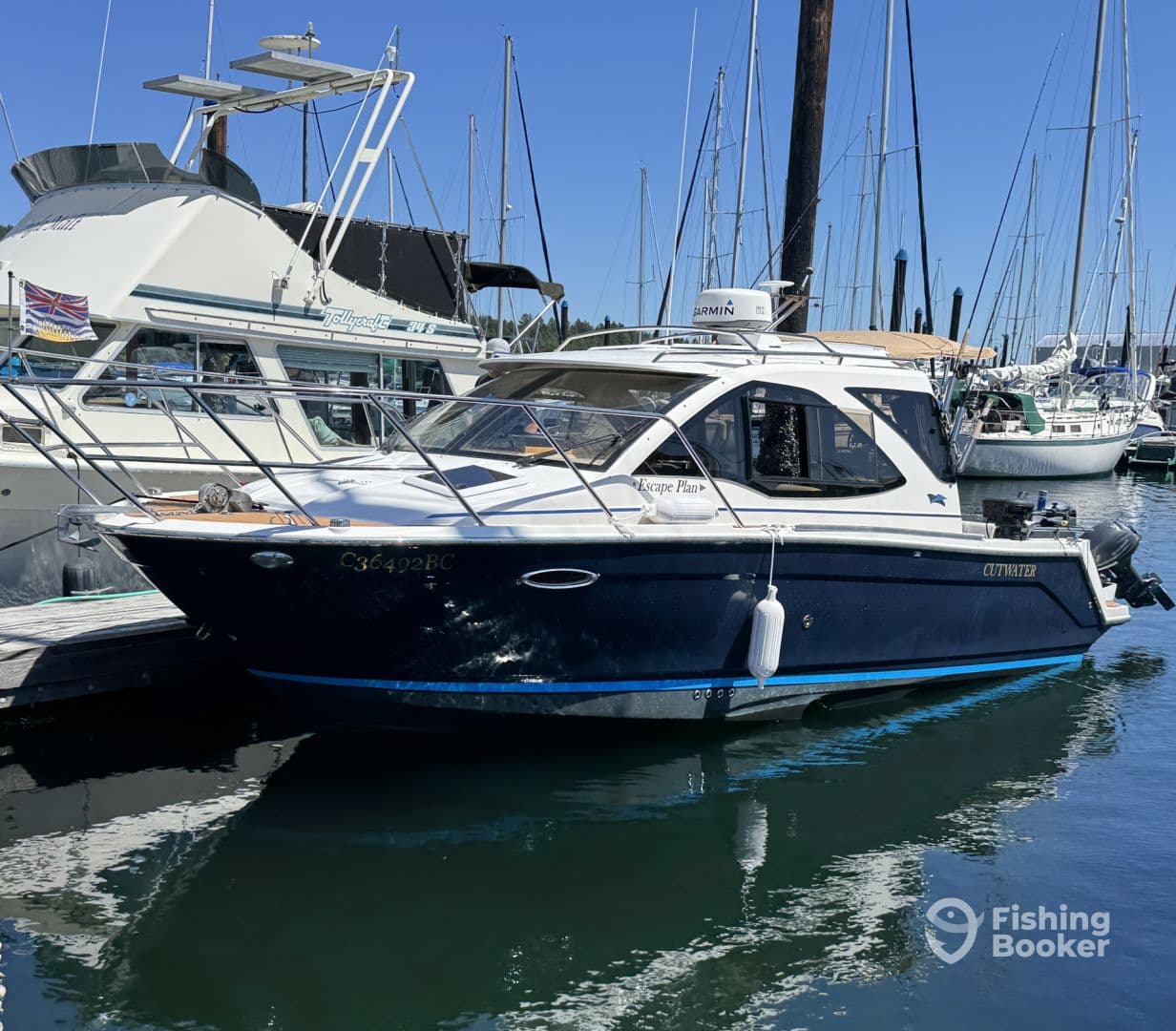 A sleek Cutwater boat docked at the marina, showcasing its modern design and surrounding sailboats.