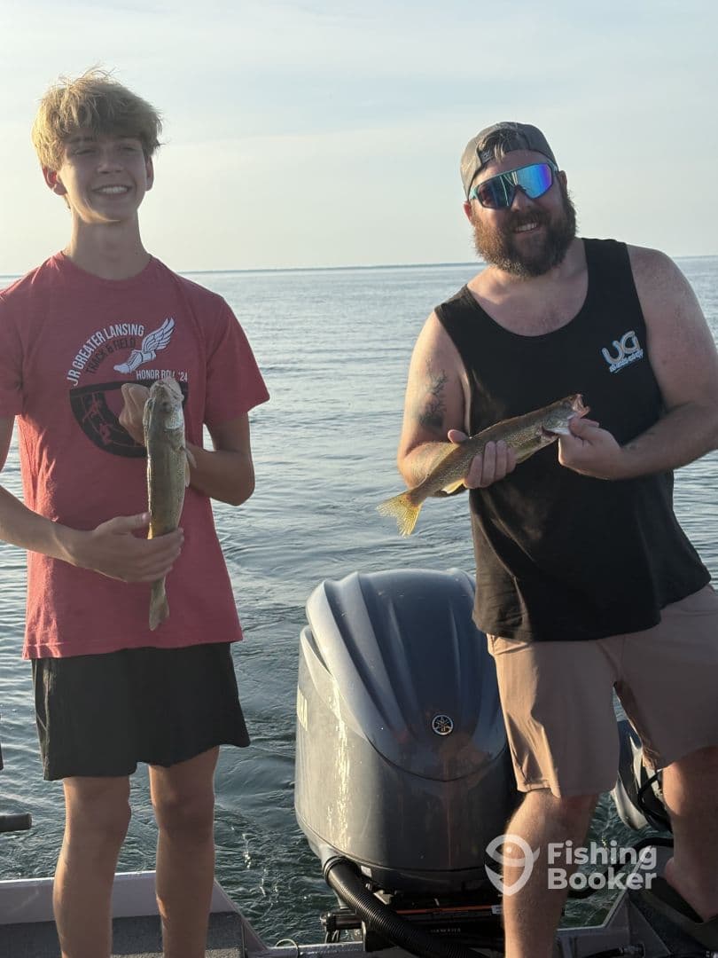 A young angler and an adult proudly displaying their catches of Walleye while fishing on a boat, showcasing a successful day on the water.