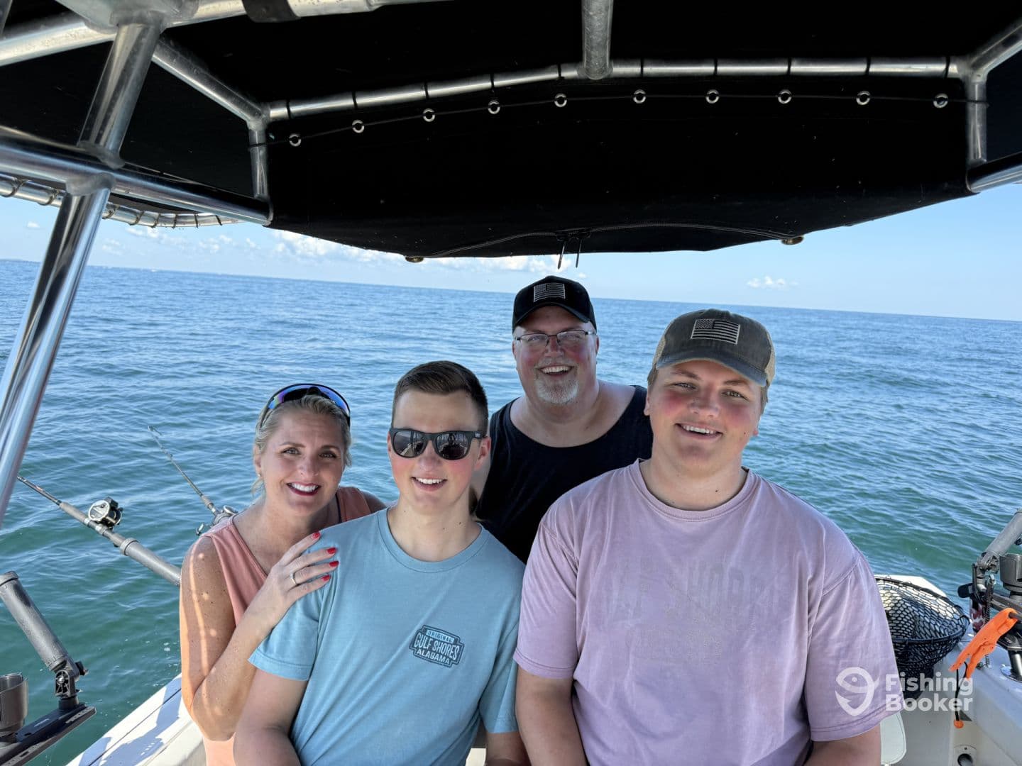 A family enjoying a day on the water, posing inside the boat with a scenic ocean backdrop.
