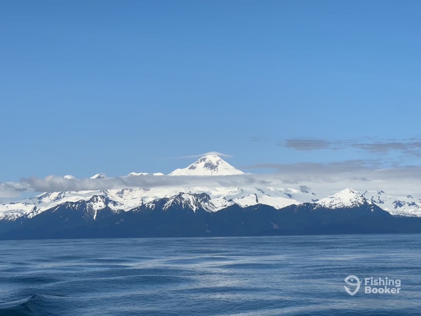 A scenic view of snow-capped mountains under a clear blue sky, showcasing the stunning natural beauty of the fishing environment.