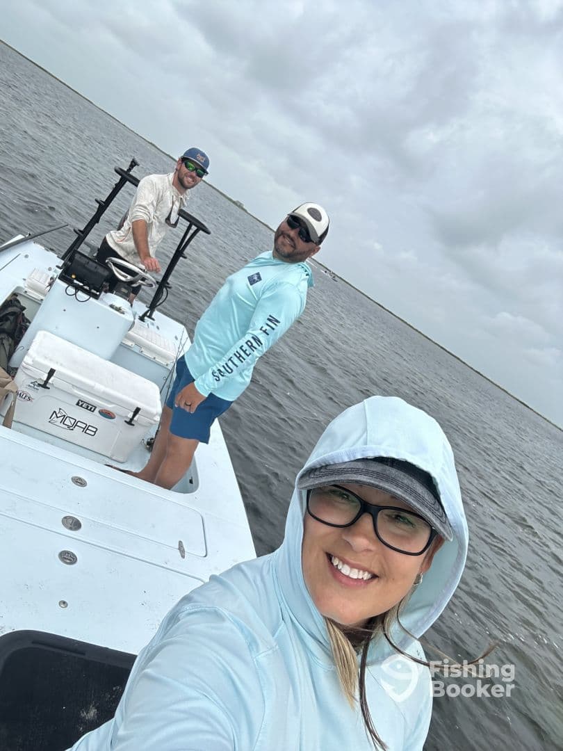 Three anglers enjoying a day on a fishing boat in calm waters, showcasing a relaxed atmosphere.