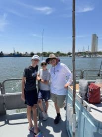 A group of young anglers enjoying their time aboard a fishing boat, showcasing a fun day on the water.