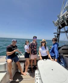 A family enjoying a day on the water aboard a fishing boat, showcasing a relaxed atmosphere with scenic ocean views.