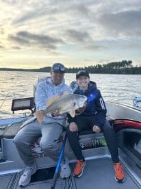 A proud moment on the water as a young angler and an adult display a large Walleye caught during a fishing trip.