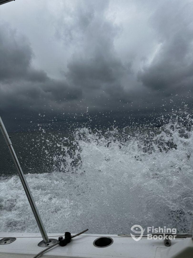 A dynamic shot capturing the splashing water from the boat's wake under a cloudy sky, suggesting an adventurous day on the water.