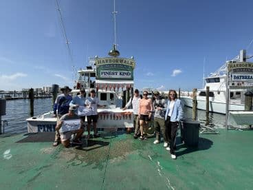 A group of anglers proudly displaying their catch of Red Snapper in front of the Finest Kind charter boat at Harborwalk Marina.