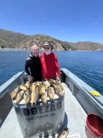 Two anglers proudly posing with a large catch of Yellowtail on a fishing charter near San Pedro, CA.
