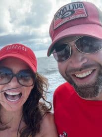 A joyful couple enjoying their time on the water, with the ocean in the background.