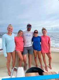 A group of young anglers enjoying a day on the boat, showcasing camaraderie and excitement for fishing.