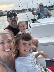 A family enjoying their time on a fishing boat, with smiles all around as they prepare for a fishing adventure.