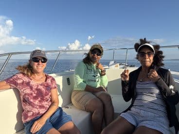 Three women enjoying a relaxing moment on the boat, showcasing a comfortable interior while out on the water.