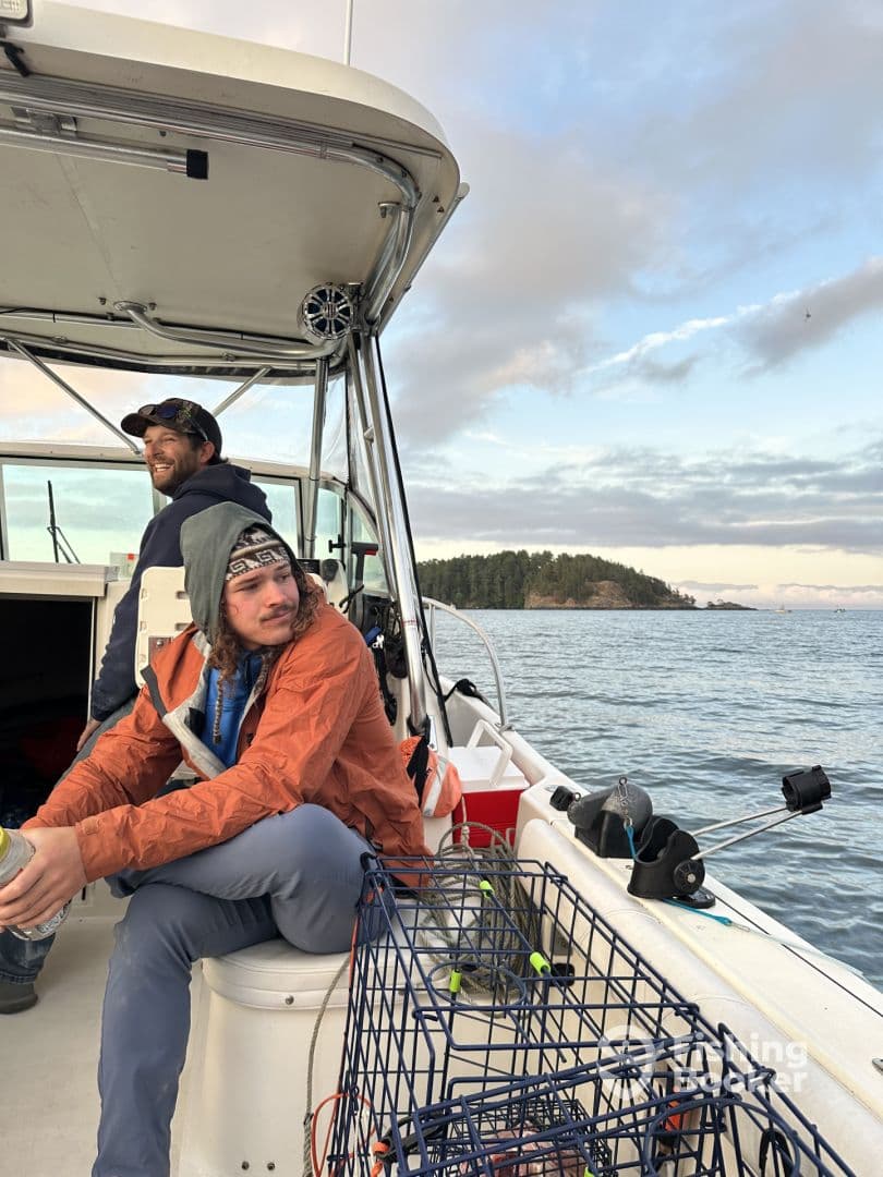 Two anglers relaxing inside a boat, enjoying the scenic view while preparing for their fishing adventure.