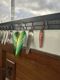 A close-up view of various fishing lures displayed inside the boat, showcasing colorful designs ideal for attracting fish.