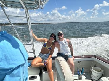 Two anglers enjoying a sunny day on a boat, showcasing a relaxed atmosphere while cruising on the water.