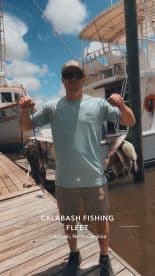 An angler proudly displaying a catch of Black Sea Bass and Flounder at the Calabash Fishing Fleet in North Carolina.