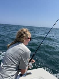 A young angler casting a line while fishing on a sunny day in open waters, showcasing the excitement of the sport.