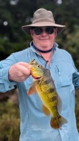 An angler proudly displaying a vibrant Largemouth Bass caught during a freshwater fishing trip.
