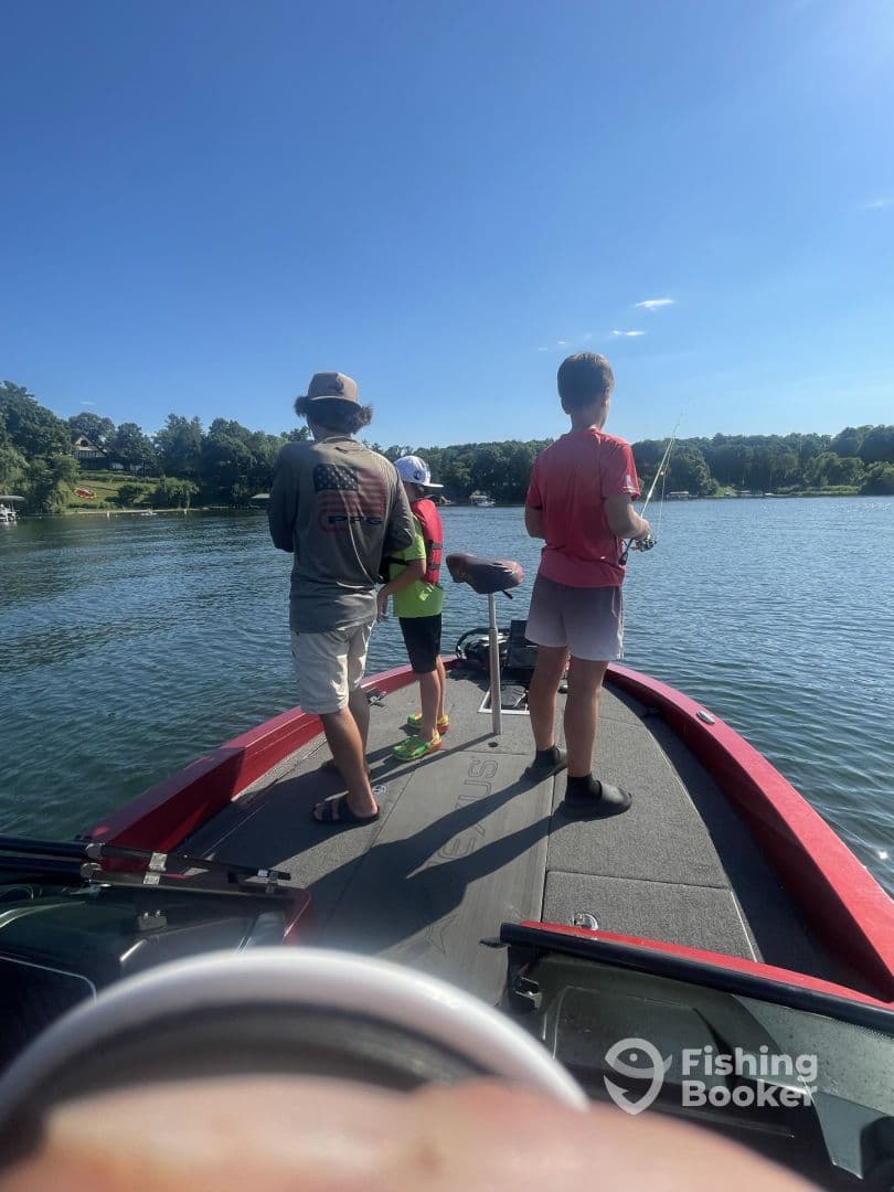 A group of young anglers fishing from a boat on a sunny day, showcasing the excitement of the fishing experience.