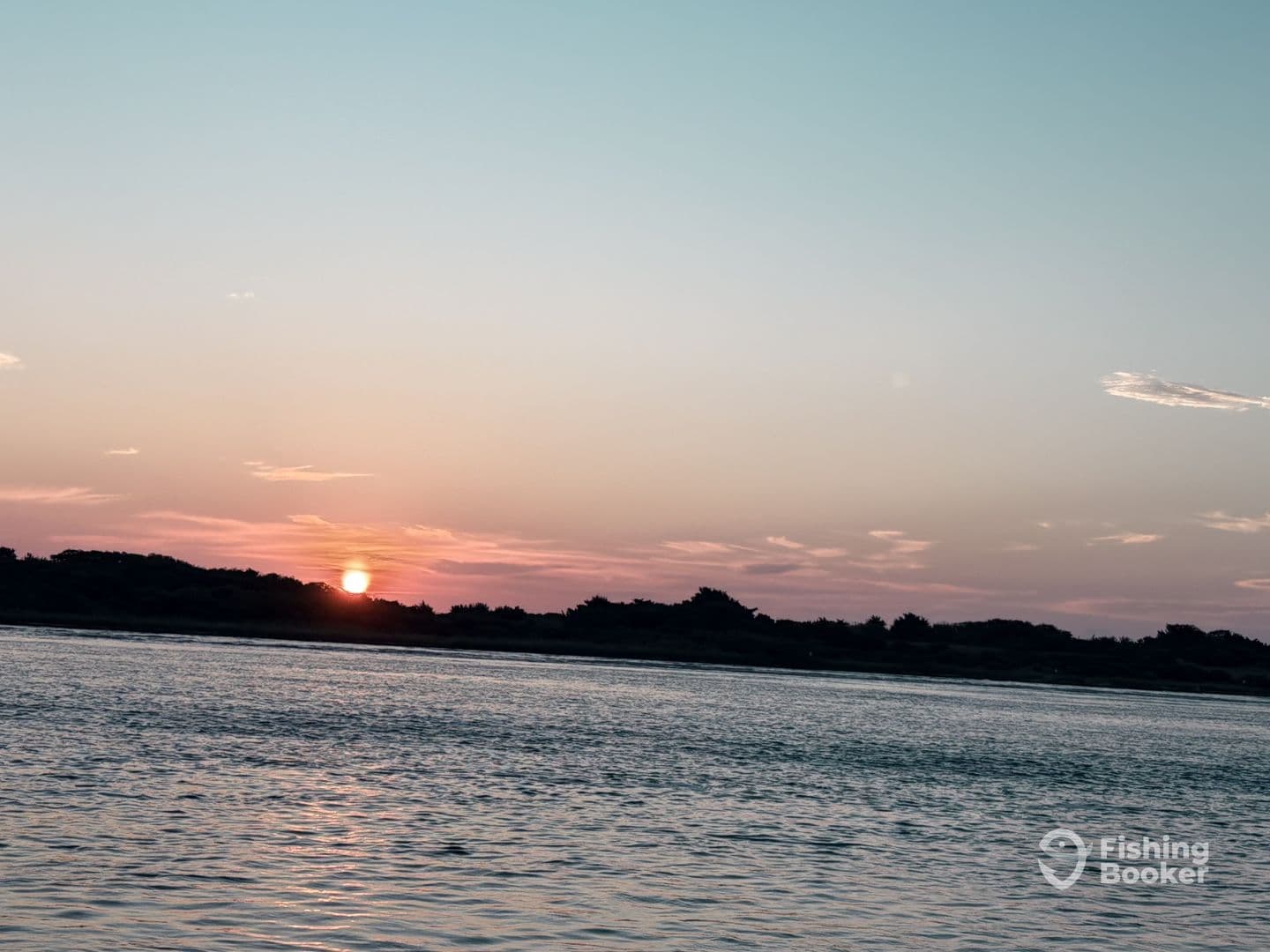 A serene sunset over calm waters, capturing the tranquil beauty of a fishing environment.