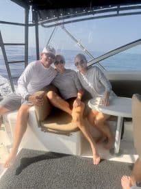 Three friends enjoying a relaxing moment inside a boat, showcasing comfortable seating and a scenic ocean view.