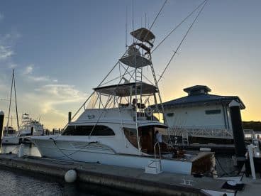 A sleek sportfishing yacht named 'Waterford' docked at sunset, showcasing its impressive design and fishing gear.