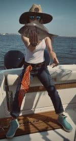 Angler proudly displaying a freshly caught fish while enjoying a day on the water aboard a Boston Whaler.