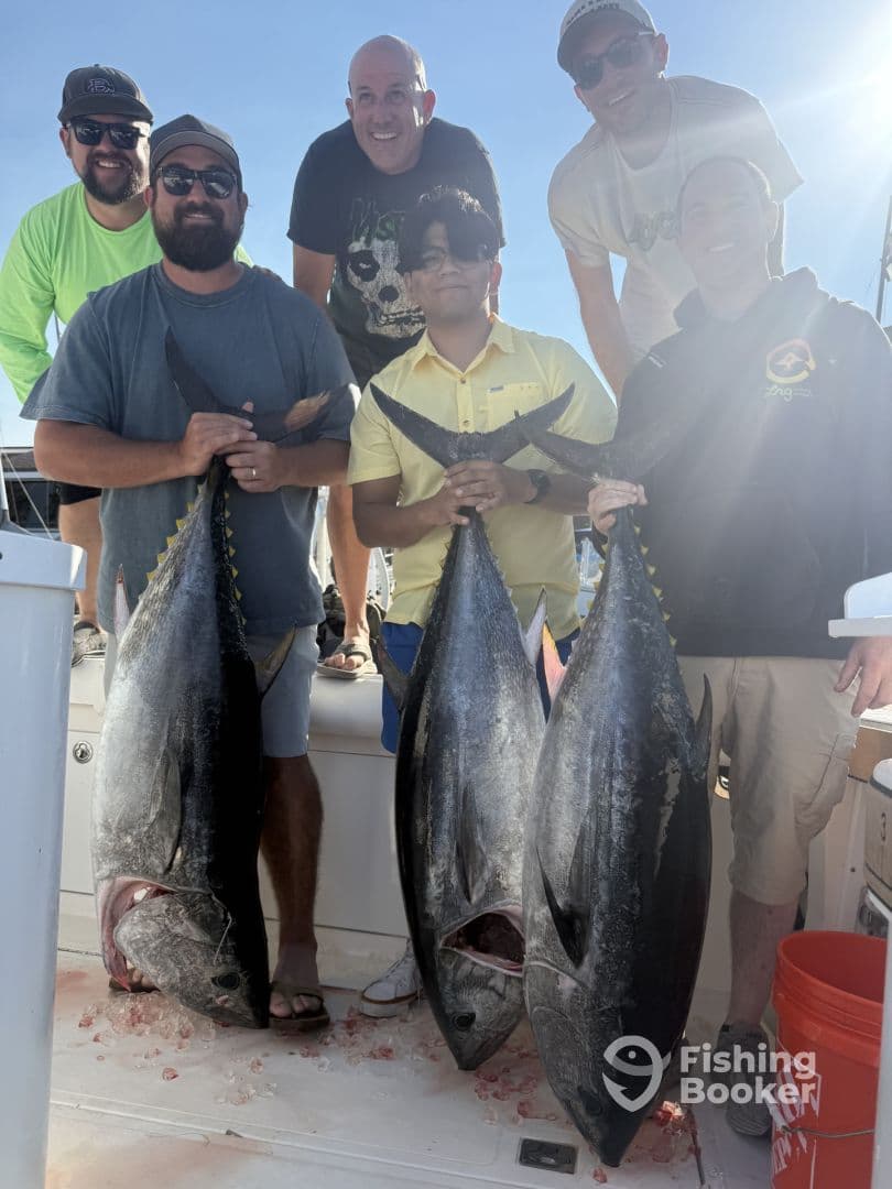 A group of anglers proudly displaying their large Yellowfin Tuna catches on a fishing charter, showcasing a successful day on the water.