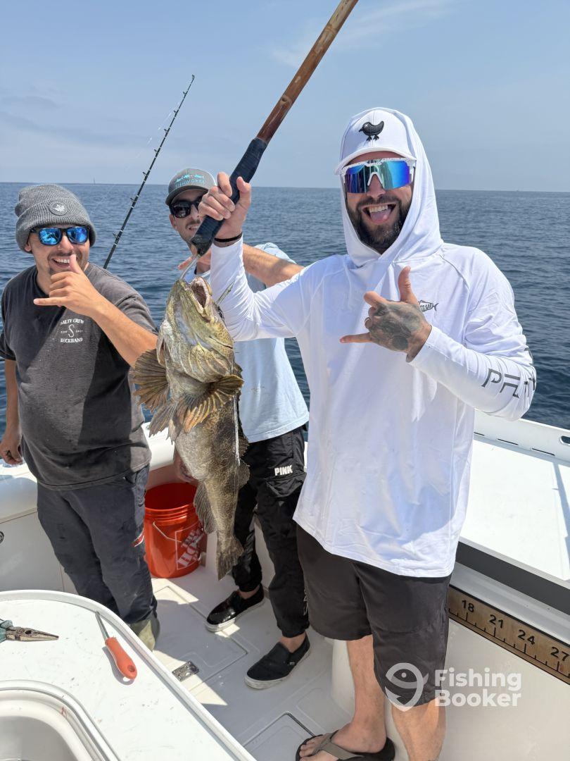 A group of anglers celebrating a successful catch of a large grouper while fishing offshore, showcasing camaraderie and excitement.