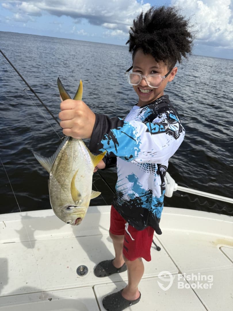 A young angler proudly displaying a large fish while fishing on a boat, showcasing a vibrant fishing environment.