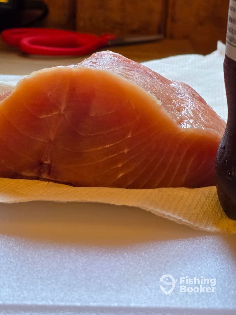 A fresh fillet of fish displayed on a cleaning station, showcasing the quality of the catch after a successful fishing trip.
