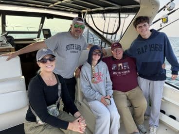 A family enjoying their time aboard a fishing boat, showcasing a relaxed atmosphere with scenic ocean views.
