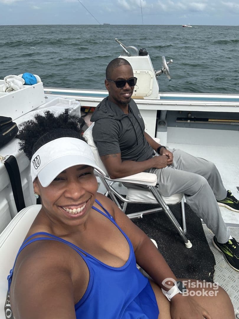 Two anglers enjoying a relaxing moment on the boat, showcasing comfortable seating and a scenic ocean backdrop.