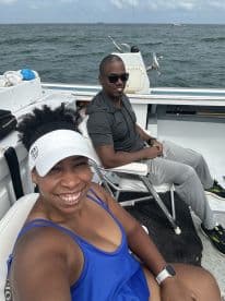 Two anglers enjoying a relaxing moment on the boat, showcasing comfortable seating and a scenic ocean backdrop.